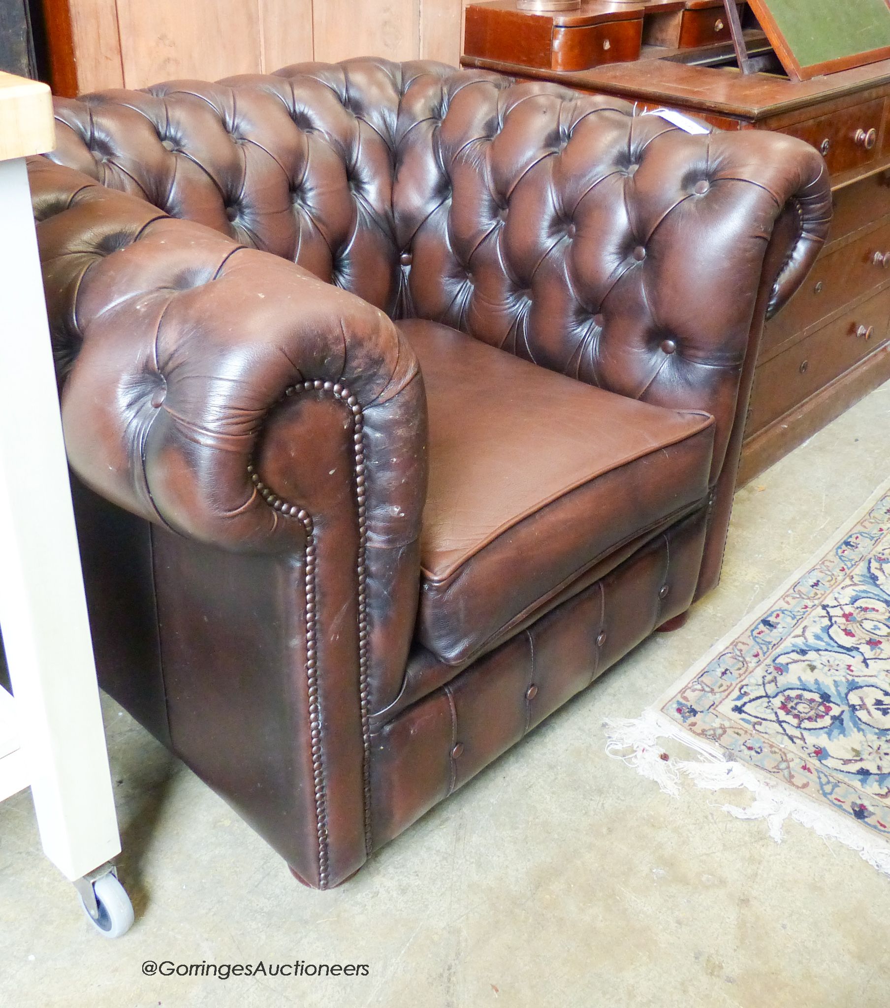 A buttoned brown leather Chesterfield armchair.